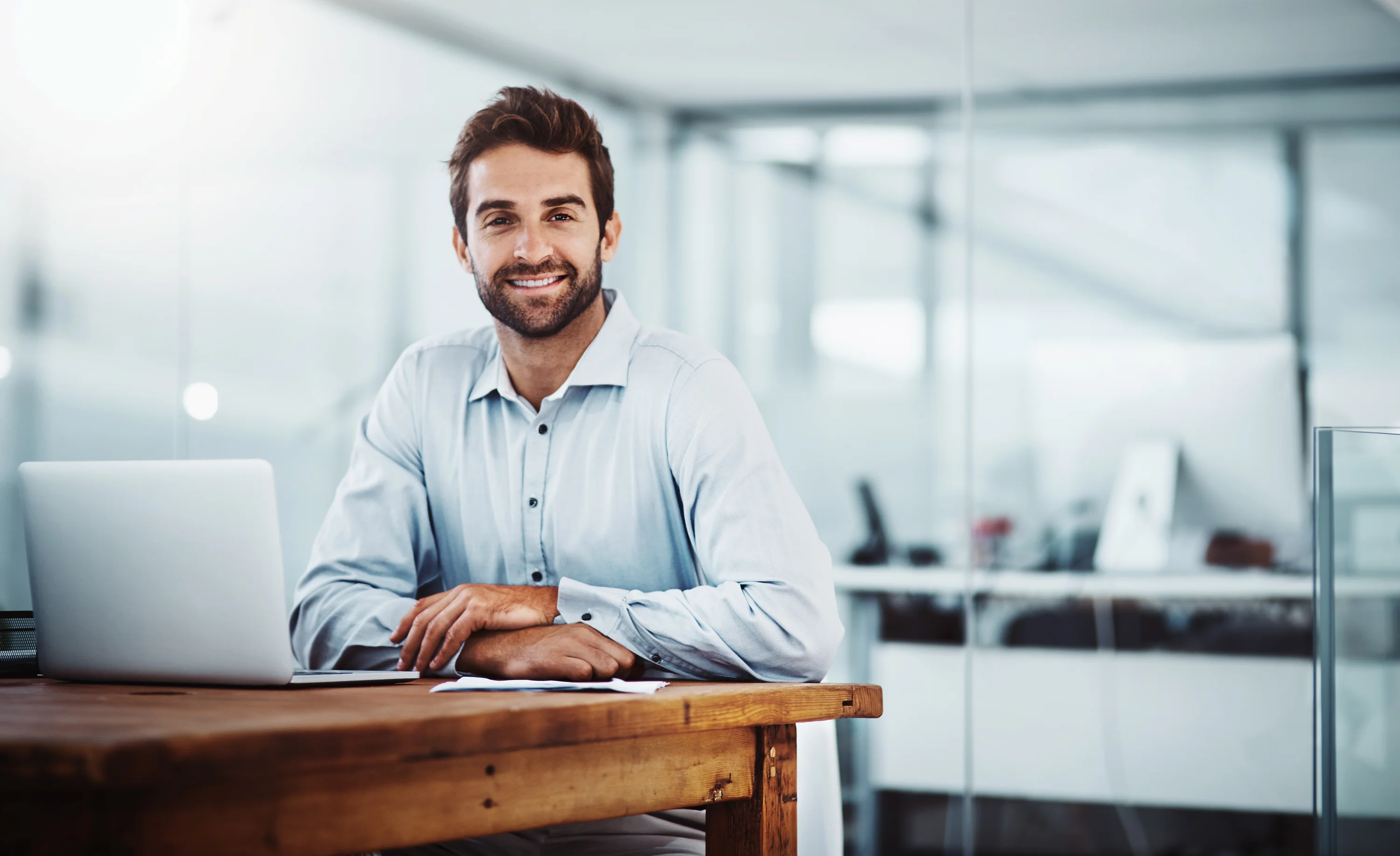 Homme d'affaires souriant à la caméra dans un bureau
